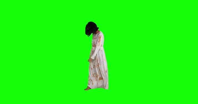 Scary zombie woman walking in the studio while wearing bloody gown. Shot in 4k resolution with green screen background