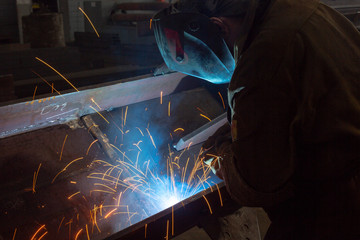 Worker at the factory welding closeup Industrial shot sparks