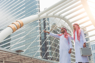 Two Arab businessmen are exploring investment locations, planning new business projects.