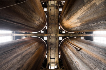 Symmetrical shot of four rusty industrial silos