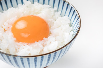 白い背景にお茶碗に白ご飯に生卵  卵かけご飯egg rice 