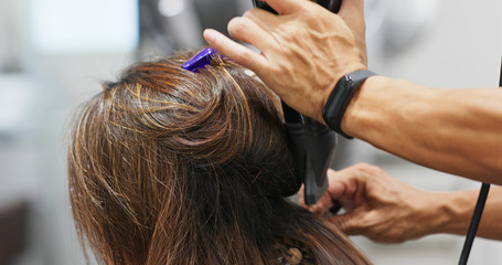 Hair stylist dry hair in hair salon