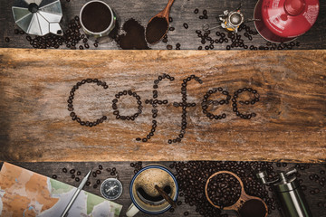 equipment material about coffee beans. Top view with copy space for your text. Coffee message write on a wooden table. Concept travel with map.