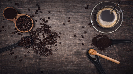 Obraz na płótnie Canvas Brown coffee beans And a cup of hot coffee placed on a wooden table with honey. Wooden background with espresso and beans. Top view with copy space for your text.