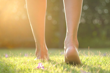 Leg of woman is on the ground. She is about to walk down the grass to exercise in the morning....