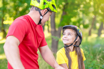 Naklejka premium Father communicates with his daughter, teaching her how to ride a bicycle