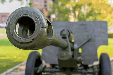 a sample of a military cannon close-up on the background of a residential area