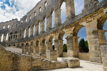 The northwestern part of the amphitheater wall in Pula, behind the trees is the sea