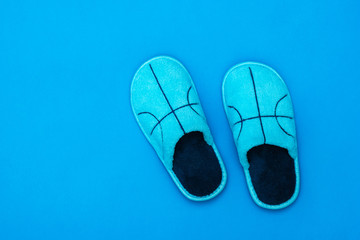 Blue Slippers with embroidery on a blue background. The view from the top. Flat lay. Color trend.