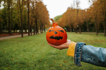 Halloween pumpkin. Woman holding a scary face pumpkin. Happy Halloween party holiday. Celebrate...