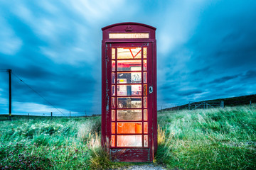 Close up of an old british curbside telephone booth in a lonely countryside setting