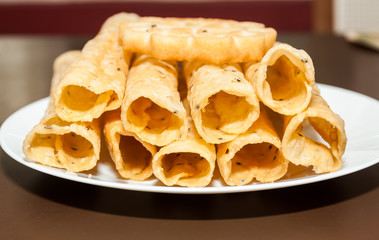 Closeup of Kerala dessert Kuzhalappam in a plate on brown background 