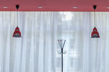 lampshades hanging from the ceiling, shot against a window
