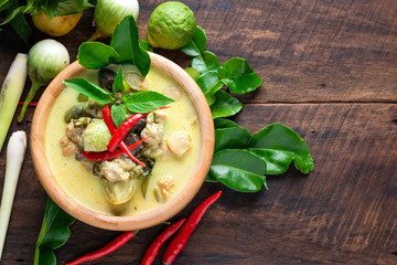 Thai food traditional green curry in wooden cup with coconut on wooden table