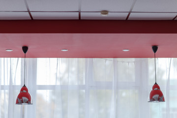 lampshades hanging from the ceiling, shot against a window