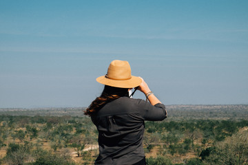 adventurous girl taking a shot during the holidays to the panorama in the savannah