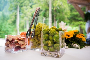 Close up of square crystal cups of fruit against a green bokeh background