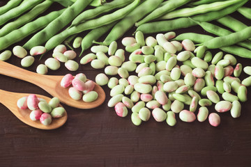 green bean pods and peeled beans on wooden background. beans closeup. background with green raw beans.