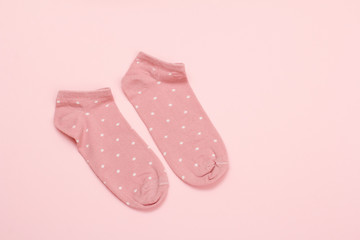 Pair of women socks on pink background.