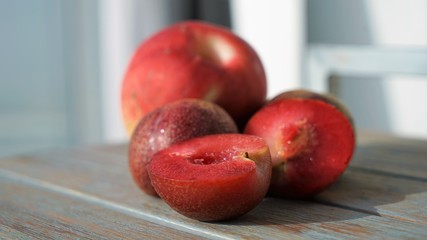 red plums and peaches on wooden surface