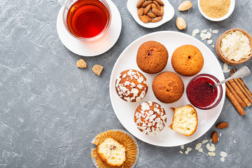 Homemade muffins with almond flakes and raspberry jam.