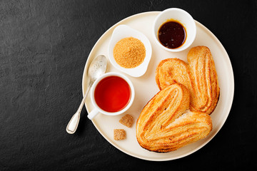 Palmiers (elephant ears), puff pastry cookie with cup of tea, breakfast concept.