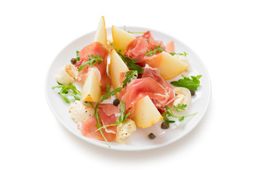 Melon and prosciutto ham salad with Mozzarella and arugula leaves.isolated on white background