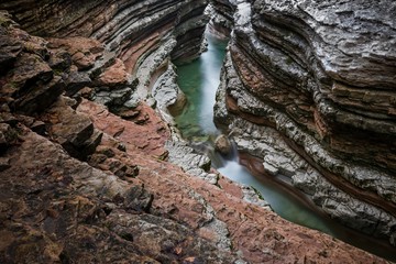 Vista dall'alto del canyon del Brent De L'art, con gli strati di roccia colorati e, in fondo, il torrente dall'acqua smeraldo