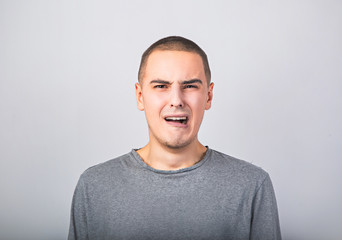 Fototapeta premium Unhappy crying man with grimacing face. Closeup studio portrait