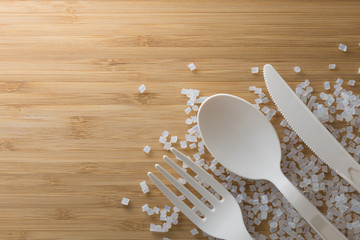 Biodegradable plastic pellets, spoon and fork made from starch and renewable sources - obrazy, fototapety, plakaty