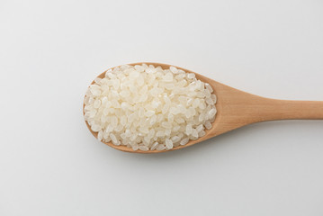 Top view of Japanese rice in wooden spoon white background isolate