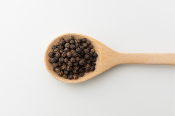 Top view of black peppercorn in wooden spoon white background isolate