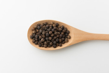 Top view of black peppercorn in wooden spoon white background isolate