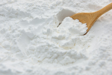 Close-up of tapioca starch or flour powder in wooden spoon with starch background