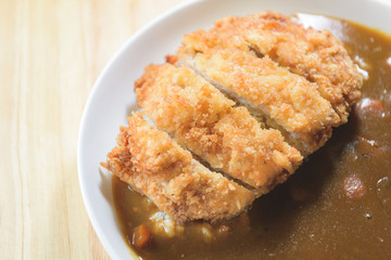 A deep fried pork cutlet topped with Japanese curry and rice