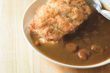 A deep fried pork cutlet topped with Japanese curry and rice