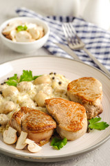 Fried pork with mushrooms in a creamy sauce.