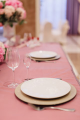 Table decoration with fresh flowers in pastel colors. Elegant dining table in peach-pink color. Luxurious flowers composition. Indoors wedding. Tablecloth lilac color. Beautiful table setting.