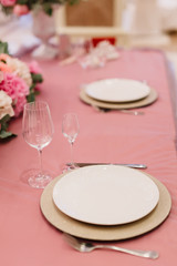 Table decoration with fresh flowers in pastel colors. Elegant dining table in peach-pink color. Luxurious flowers composition. Indoors wedding. Tablecloth lilac color. Beautiful table setting.