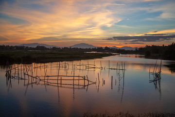Beautiful sunset in Vietnam, fishing nets on the river, sunset on a background of mountains, Hoi An, Vietnam