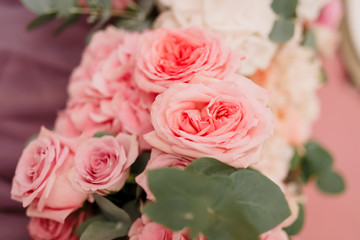 Table decoration with fresh flowers in pastel colors. Elegant dining table in peach-pink color. Luxurious flowers composition. Indoors wedding. Tablecloth lilac color. Beautiful table setting.