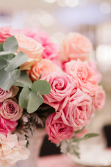 Table decoration with fresh flowers in pastel colors. Elegant dining table in peach-pink color. Luxurious flowers composition. Indoors wedding. Tablecloth lilac color. Beautiful table setting.