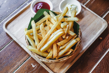 Traditional French fries with ketchup in a wicker basket