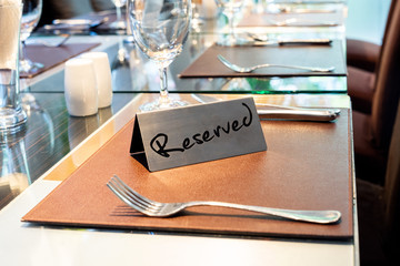Reserved Metal Plate on the Table with Blurry background. Reservation Seat at restaurant.