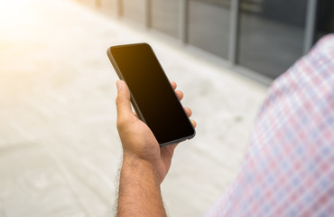 Close-up male hands using smartphone searching or social networks concept.