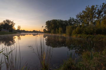 Fototapeta na wymiar Morning scenery on a cozy lake with beautiful fogs