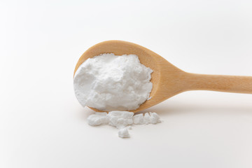 Close-up of tapioca starch or flour powder in wooden spoon on white background