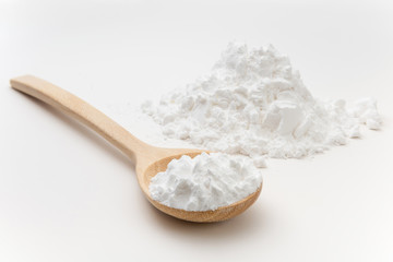 Close-up of tapioca starch or flour powder in wooden spoon on white background