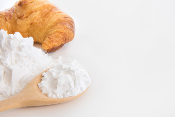Close-up of tapioca starch or flour powder in wooden spoon on white background