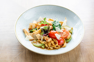Italian pasta tagliatelle with seafood and tomato sauce. Pasta Gamberini. Parmesan cheese